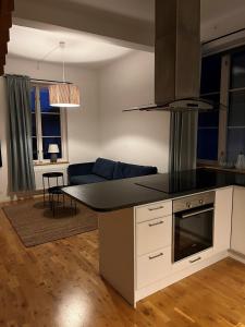 uma cozinha com um balcão e uma sala de estar em Österport - Visby Lägenhetshotell em Visby