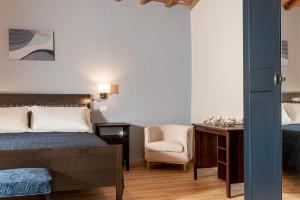 a bedroom with a bed and a desk and a chair at Podere n.8 Bio Casale Maremma in Alberese