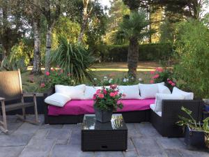 a patio with a couch with a pink blanket at La Folie in Breuil-Barret