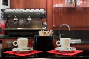 dos tazas de café sentadas en un mostrador en una cocina en Hotel Residence Vigone, en Vigone