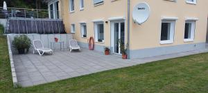 a patio with two chairs and a table next to a building at Traumblick Südpfalz in Burrweiler