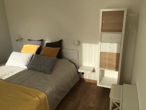um pequeno quarto com uma cama e uma cómoda em Bienvenus chez nous em Rixheim