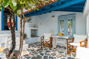 a patio with a table and chairs and a tree at The Lemon Tree House in Skopelos Town