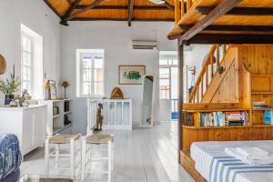 Zimmer mit einem Bett, 2 Stühlen und einer Treppe in der Unterkunft The Lemon Tree House in Skopelos