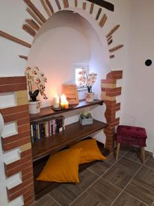 een kamer met een boekenplank met kaarsen en boeken bij La Casetta Dei Volontari in Pitigliano