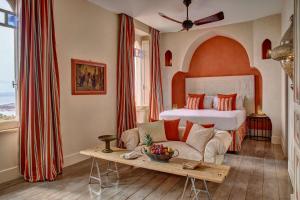 un soggiorno con letto, divano e tavolo di Palazzo Vecchio Taormina a Taormina