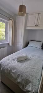 a bedroom with a bed with a white bedspread and a window at Chy Lowen - Private rooms, not en-suite, in private home with cats, close to Eden & beaches in Saint Blazey