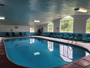 a large swimming pool in a room with chairs at Quality Inn in Wheelersburg