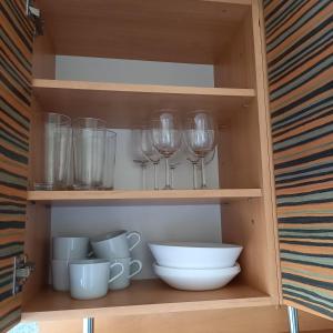 a cupboard with wine glasses and a bowl at Ozolu gatve 2- no Cēsīm 7 km in Jāņmuiža