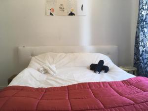a bed with a pink and white blanket on it at Beautiful 1- Bed Studio in Sollentuna in Sollentuna