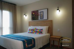 Schlafzimmer mit einem Bett und einem Fenster sowie einem Bett sidx sidx sidx in der Unterkunft Resort Quinta Santa Bárbara OFICIAL in Pirenópolis