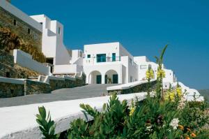 a large white building on a hill with flowers at Aegialis Hotel & Spa in Aegiali