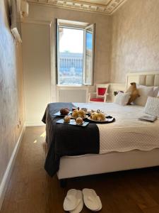 a bedroom with a bed with a tray of food on it at Piazza Venezia Luxury Suite in Rome