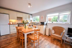 a kitchen with a table and chairs in a kitchen at 3 bedroom townhouse right on the harbour in Isle of Whithorn