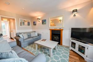 a living room with a couch and a tv at 3 bedroom townhouse right on the harbour in Isle of Whithorn