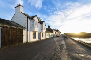 an empty street with houses on the side of the road at 3 bedroom townhouse right on the harbour in Isle of Whithorn