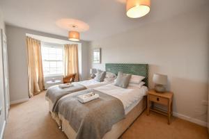 a bedroom with a large bed with two towels on it at 3 bedroom townhouse right on the harbour in Isle of Whithorn