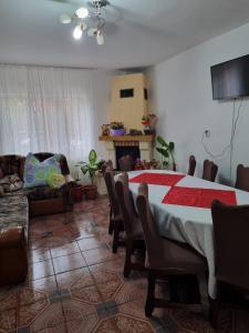 uma sala de estar com uma mesa com cadeiras e um sofá em Casa Andreea em Arieşeni