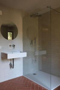 y baño con ducha acristalada y lavamanos. en Ferienhaus am Bach, Design und Sauna, en Steinberg am Rofan