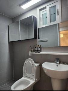 a bathroom with a toilet and a sink at Koon Terrace Stay in Seoul