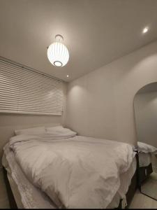 a bedroom with a large bed and a light at Koon Terrace Stay in Seoul