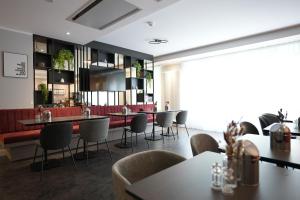 un restaurante con mesas y sillas en una habitación en Boutique Kaiser - Hotel & Apartments, en Frankfurt