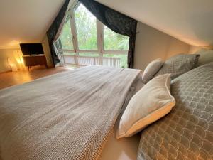 a large bed in a room with a large window at Gästehaus am Brockeswald in Cuxhaven