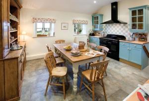 a kitchen with a wooden table and chairs at Ty Newydd in Tal-y-Cafn