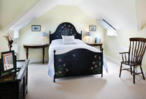 a bedroom with a black bed and two chairs at Ty Newydd in Tal-y-Cafn