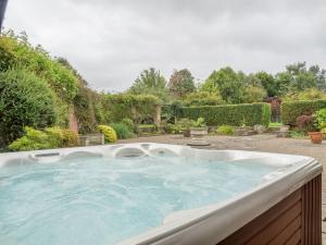 a large hot tub in a yard with trees at Bearwood House & Cottage in Pembridge