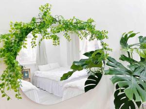a white bedroom with a white bed with plants at Near Hongik University Station Suite Room in Seoul