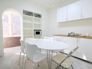 a white kitchen with a white table and chairs at Near Hongik University Station Suite Room in Seoul