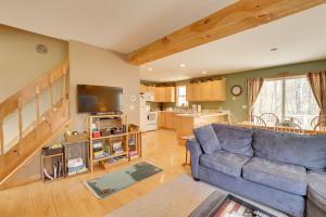 a living room with a blue couch and a kitchen at Spacious Jay Peak Vacation Rental with Mountain View in Jay