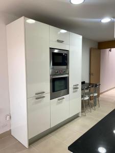cocina con armarios blancos y microondas en Casa pareada en Sant Sadurní, en Caserío de Caʼl Batista