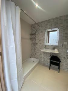 y baño con ducha, bañera y lavamanos. en Casa pareada en Sant Sadurní, en Caserío de Caʼl Batista