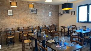 a restaurant with tables and chairs and a brick wall at CINQUE OTTAVI B&B in Santa Marinella