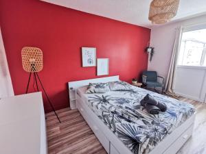 - une chambre avec un mur rouge et un lit dans l'établissement Le Théâtre du Vieux Foyal - Appartement 4 personnes à Fort-De- France, à Fort-de-France