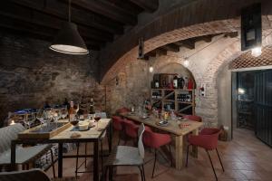 un comedor con mesas de madera y sillas rojas en Massimago Wine Suites, en Verona