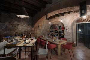 a dining room with wooden tables and red chairs at Massimago Wine Suites in Verona