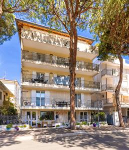 um edifício de apartamentos com varandas e árvores em Residenza Clelia Riccione em Riccione