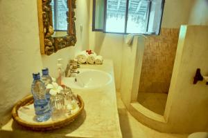 a bathroom with a sink and a mirror at Mvuvi Lodge in Watamu