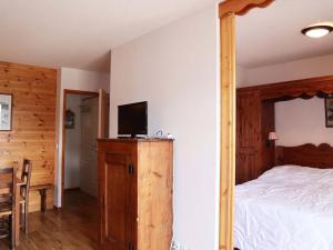 a bedroom with a bed and a tv on a wooden cabinet at Appartement Les Orres, 3 pièces, 8 personnes - FR-1-322-325 in Les Orres