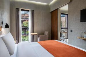 a hotel room with a bed and a desk and a window at IOTA Hotel Tbilisi in Tbilisi City +37 photos