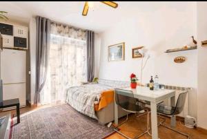 een slaapkamer met een bed, een bureau en een tafel bij Camera privata nell'appartamento in zona residenziale con 2 piscine in Rapallo