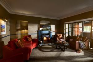 a living room with two red chairs and a fireplace at The Tongue Hotel in Tongue