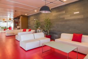 a lobby with white couches and red pillows at ILUNION Costa Sal Lanzarote in Puerto del Carmen