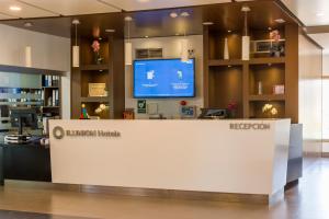 a lobby of a library with a reception desk and a tv at ILUNION Costa Sal Lanzarote in Puerto del Carmen