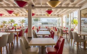 a restaurant with tables and chairs and windows at ILUNION Costa Sal Lanzarote in Puerto del Carmen