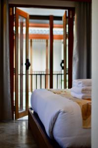 1 dormitorio con 1 cama y puerta con toallas en Phang Nga Origin Hotel, en Phang Nga