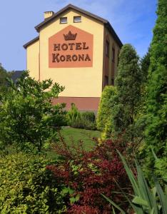 un panneau d'hôtel kronoma sur le côté d'un bâtiment dans l'établissement Hotelik Korona, à Raszyn